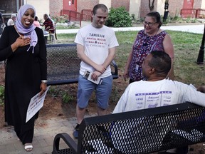 In this Monday, June 18, 2018, photo, attorney Tahirah Amatul-Wadud, left, who is challenging incumbent U.S. Rep. Richard Neal, D-Mass., greets residents of an apartment complex while campaigning in Springfield, Mass. Muslim Americans are running for elected office in numbers not seen since before the terrorist attacks of Sept. 11, 2001.