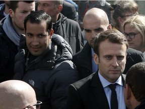 Emmanuel Macron, right, is flanked by his bodyguard, Alexandre Benalla, left, outside the Whirlpool home appliance factory, in Amiens, northern France. Investigators have detained for questioning on Friday, July 20, 2018 one of President Emmanuel Macron's top security aides caught on camera beating a protester in May, a turn of events now evolving into a major political crisis for the president.