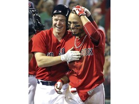 Boston Red Sox's Mookie Betts, right, celebrates his walk-off solo home run with teammate Brock Holt during the 10th inning of the team's baseball game against the Minnesota Twins at Fenway Park, Friday, July 27, 2018, in Boston. The Red Sox won 4-3.