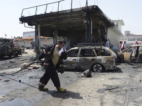 Firefighters work at the site of a deadly suicide attack in Jalalabad, the capital of Nangarhar province, Afghanistan, Tuesday, July 10, 2018. An Afghan official said at least 10 people, including two intelligence service agents and eight civilians, have been killed in the suicide attack in eastern Afghanistan.