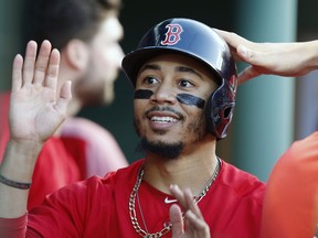 Boston Red Sox's Mookie Betts celebrates after scoring on a single by Brock Holt during the second inning of a baseball game against the Toronto Blue Jays in Boston, Friday, July 13, 2018.