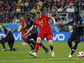 Belgium's Kevin De Bruyne, center, and France's Samuel Umtiti challenge for the ball during the semifinal match between France and Belgium at the 2018 soccer World Cup in the St. Petersburg Stadium in, St. Petersburg, Russia, Tuesday, July 10, 2018.
