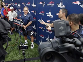 New England Patriots head coach Bill Belichick, center, takes questions from members of the media before the start of NFL football practice, Thursday, July 26, 2018, in Foxborough, Mass.
