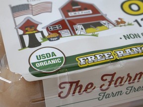 In this Monday, July 9, 2018 photo a "USDA Organic" label is printed on the label of a carton of a dozen eggs, in Walpole, Mass. The USDA Organic label generally signifies a product is made without synthetic pesticides and fertilizers, and that animals are raised according to certain standards. But disputes over the rules and reports of fraud may have some questioning whether the seal is worth the price.