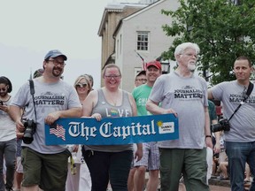 Current and former Capital Gazette staff members march in the Annapolis 4th of July parade in Annapolis, Md., Wednesday, July 4, 2018. The Baltimore Sun reports that a few dozen current and former journalists from the Capital Gazette, where five employees were shot to death, participated in the Wednesday evening parade, where they were greeted by supportive whistles, cheers and applause. Several staffers T-shirts reading "journalism matters," while others in the parade wore T-shirts that said, "press on."
