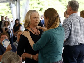 Judy Hiaasen, left, sister of Rob Hiaasen, one of the journalists killed in the shooting at The Capital Gazette newspaper offices, speaks with a mourner during a memorial service, Monday, July 2, 2018, in Owings Mills, Md.