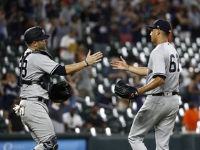 New York Yankees catcher Austin Romine, left, and relief pitcher Giovanny Gallegos high-five after closing out the second baseball game of a doubleheader against the Baltimore Orioles, Monday, July 9, 2018, in Baltimore. New York won 10-2.