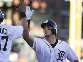 Detroit Tigers' James McCann, right, is greeted at home plate by Jim Adduci after they scored on McCann's two-run home run in the second inning of a baseball game against the Texas Rangers, Friday, July 6, 2018, in Detroit.