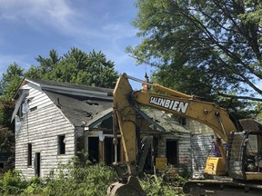 Demolition equipment sits outside a vacant house on Detroit's east side, Wednesday, July 18, 2018. The city has torn down more than 14,000 structures over the past four years. Concern over contaminated dust from lead-based paint in older houses has resulted in the city pushing back some demolitions in parts of the city where elevated blood lead levels have been found in children.