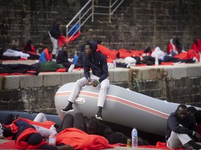Migrants rest at the port of Tarifa, southern Spain, as they wait to be moved after being rescued by Spain's Maritime Rescue Service in the Strait of Gibraltar, in Tarifa, Spain. Maritime rescue authorities say 751 migrants have been plucked Friday from 52 dinghies trying to reach Spanish shores from northern Africa, this year's most popular route into Europe.