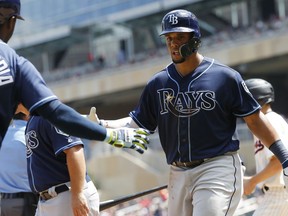 Tampa Bay Rays' Carlos Gomez, right, is congratulated by Adeiny Hechavarria after scoring on a ground-rule double by Malex Smith during the fourth inning of a baseball game against the Minnesota Twins, Saturday, July 14, 2018, in Minneapolis.