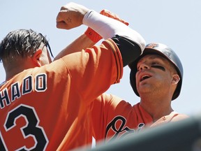 Baltimore Orioles' Chris Davis, right, celebrates his two-run home run off Minnesota Twins pitcher Kyle Gibson with Manny Machado in the first inning of a baseball game Saturday, July 7, 2018, in Minneapolis.