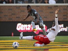 Minnesota United forward Carlos Darwin Quintero (25) watches his shot rolls past New England Revolution defender Jalil Anibaba before it landed in the net during the first half of an MLS soccer match in Minneapolis Wednesday, July 18, 2018.