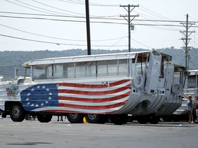 People look at idled duck boats in the parking lot of Ride the Ducks Saturday, July 21, 2018 in Branson, Mo. One of the company's duck boats capsized Thursday night resulting in several deaths on Table Rock Lake.