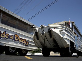 A man looks at an idled duck boat in the parking lot of Ride the Ducks Saturday, July 21, 2018 in Branson, Mo. One of the company's duck boats capsized Thursday night resulting in several deaths on Table Rock Lake.