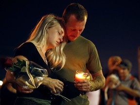 Brandon Webb and Carlye Michel participate in a candlelight vigil in the parking lot of Ride the Ducks Friday, July 20, 2018, in Branson, Mo. One of the company's duck boats capsized Thursday night resulting in over a dozen deaths on Table Rock Lake.