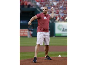 Jason Seaman, a science teacher at Noblesville (Ind.) West Middle School, throws out a ceremonial pitch before a baseball game between the St. Louis Cardinals and the Atlanta Braves on Friday, June 29, 2018, in St. Louis. Seaman was shot three times while stopping a male student with two handguns in the school.