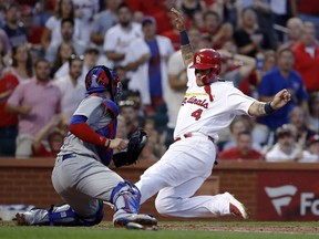 St. Louis Cardinals' Yadier Molina (4) scores past Chicago Cubs catcher Victor Caratini during the third inning of a baseball game Friday, July 27, 2018, in St. Louis.
