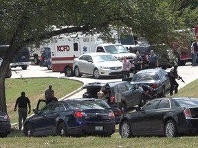 Authorities mobilize near 27th Street and Van Brunt Boulevard after three police officers were shot Sunday, July 15, 2018, in Kansas City, Mo., while trying to arrest a person of interest in the shooting death of a university student on July 6. The suspect died in an exchange of gunfire with police. The officers suffered non-life threatening injuries.