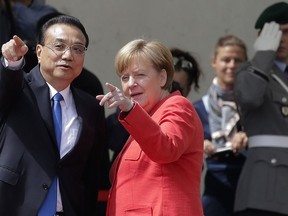 German Chancellor Angela Merkel, right, and Chinese Premier Li Keqiang look to spectators during a meeting in the chancellery in Berlin, Monday, July 9, 2018.