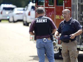 Law enforcement officers stand guard at the entrance to the Social Security office in McComb, Miss., following a report of an attack Monday, July 9, 2018.