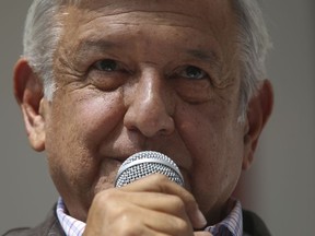 Mexico's President-elect Andres Manuel Lopez Obrador speaks to reporters from his party's headquarters in Mexico City, Sunday, July 15, 2018. Lopez Obrador says he plans to earn 40 percent of what his predecessor makes when he takes office in December as part of an austerity push in government.