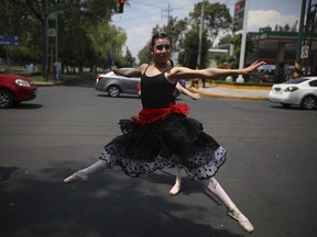 A ballerina dances at a traffic light stop, in Mexico City, Saturday, July 28, 2018. In this sprawling megalopolis notorious for its clogged streets, a theater company sent out tutu-clad dancers out to delight motorists at snarled intersections with snippets from ballet classics like The Nutcracker and Swan Lake all in the 58 seconds it takes for the light to go from red to green.