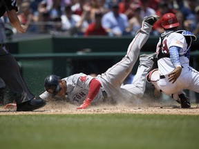 Boston Red Sox' Rafael Devers, left, slides home past Washington Nationals catcher Pedro Severino to score on a sacrifice fly by Jackie Bradley Jr., during the seventh inning of a baseball game Wednesday, July 4, 2018, in Washington.