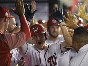 Washington Nationals' Trea Turner, center, is congratulated in the dugout after his grand slam during the sixth inning of a baseball game against the Miami Marlins on Thursday, July 5, 2018, in Washington. The Nationals won 14-12.