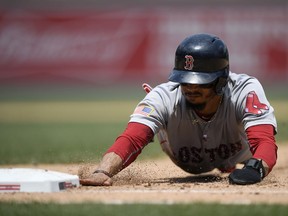 Boston Red Sox' Mookie Betts dives back to first safely on a pick-off attempt during the sixth inning of a baseball game against the Washington Nationals, Wednesday, July 4, 2018, in Washington. The Red Sox beat the Nationals 3-0.