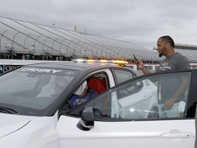 New England Patriots safety Patrick Chung takes a picture of his name on the pace car before taking a practice run before the NASCAR Cup Series auto race Sunday, July 22, 2018, at New Hampshire Motor Speedway in Loudon, N.H.