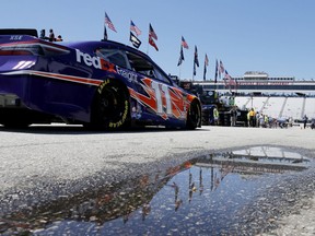 NASCAR Cup Series driver Denny Hamlin drives past a puddle reflecting the grandstands during auto racing practice Friday, July 20, 2018, at New Hampshire Motor Speedway in Loudon, N.H. Rain is in the forecast for Sunday's race.