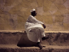 In this May 7, 2018, photo, 65-year old Mohammed Haroun sits in front of his home in Wadi Karkar, a new complex under construction in the desert west of Lake Nasser, Aswan, Egypt. Evicted from their ancestral lands to make way for the world's largest man-made lake behind the Aswan Dam, Egypt's Nubians have found both pain and nostalgia in memories of the peaceful and uncorrupted life they once had.