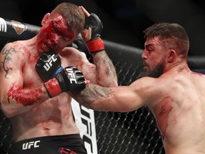 Mike Perry, right, hits Paul Felder during a welterweight mixed martial arts bout at UFC 226, Saturday, July 7, 2018, in Las Vegas.