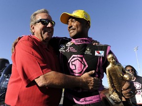 FILE - In this Oct. 27, 2013, file photo, Antron Brown, right, celebrates with team owner Don Schumacher after winning in Top Fuel at the NHRA Toyota Nationals drag races t Las Vegas Motor Speedway in Las Vegas. All seven members of the world's largest hotrod team, Don Schumacher Racing, pledged their brains to concussion research Friday, July 20, 2018, as part of an effort geared to reach military members as much as racing fans. Through its sponsorship with the U.S. Army, Schumacher connected with the Infinite Hero Foundation, a nonprofit that works with the Concussion Legacy Foundation. CLF has received pledges of more than 3,500 brains to conduct post-mortem research on the effects of CTE _ a disease linked to repetitive head injuries seen in football and other contact sports, and also in military personnel.
