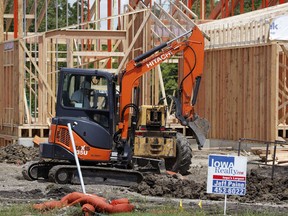 FILE In this this  June 27, 2018 file photo, construction continues on a home behind a for sale sign in Waukee, Iowa.  U.S. homebuilders sharply curtailed the pace of construction in June as housing starts plummeted 12.3 percent. The Commerce Department said Wednesday, July 18,  that housing starts fell to a seasonally adjusted annual rate of 1.17 million from 1.34 million in May.