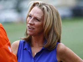 FILE - In this Saturday, July 29, 2017, file photo, broadcaster Beth Mowins chats with a reporter at the Denver Broncos NFL football training camp in Englewood, Colo. ESPN is going with a fresh approach for its first 2018 regular-season broadcast of "Monday Night Football." Two announcers with plenty of NFL credentials but far more entrenched in the college game these days will be handling the Jets-Lions game from Detroit: Beth Mowins and Brian Griese.