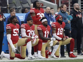 FILE - In this Dec. 24, 2017, file photo, San Francisco 49ers outside linebacker Eli Harold, from bottom left, kneels with safety Eric Reid, wide receiver Marquise Goodwin and wide receiver Louis Murphy during the national anthem before an NFL football game against the Jacksonville Jaguars in Santa Clara, Calif. The NFL Players Association filed a grievance with the league challenging its national anthem policy. The union says that the new policy, which the league imposed without consultation with the NFLPA, is inconsistent with the collective bargaining agreement and infringes on player rights.