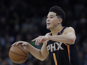 FILE - In this Jan. 5, 2018, file photo, Phoenix Suns guard Devin Booker (1) gestures during the second half of the team's NBA basketball game against the San Antonio Spurs in San Antonio. Booker, the high-scoring guard at the heart of Phoenix's rebuilding plans, has signed a five-year, $158 million maximum contract with the Suns. Booker, 21, tweeted a photo of himself smiling as he signed the deal Saturday night, July 7, moments before the Suns announced the deal.