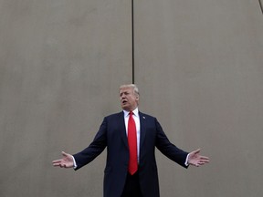 FILE - In this March 13, 2018, file photo, President Donald Trump speaks during a tour as he reviews border wall prototypes in San Diego. Trump said Sunday, July 29, 2018, that he would consider shutting down the government if Democrats refuse to vote for his immigration proposals, including building a wall along the U.S.-Mexico border.