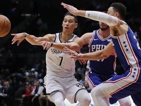 FILE - In this Oct. 11, 2017, file photo, Brooklyn Nets guard Jeremy Lin (7) passes the ball as Philadelphia 76ers guards Ben Simmons, right, and JJ Redick (17) defend during the third quarter of a preseason NBA basketball game in Uniondale, N.Y. A person with knowledge of the details says the Nets have agreed to trade Lin to the Atlanta Hawks. The Nets made the move to ease an overcrowded point guard spot early Friday morning, July 13, 2018, the person told The Associated Press on condition of anonymity because the trade had not been announced.
