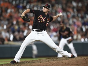 FILE - In this July 14, 2018, file photo, Baltimore Orioles' Zach Britton throws to a Texas Rangers batter during the ninth inning of a baseball game in Baltimore. A person familiar with the talks tells The Associated Press the New York Yankees are close to agreement on a trade to acquire Britton from the rebuilding Orioles for three prospects, a deal that would bolster New York's bullpen for the stretch run.