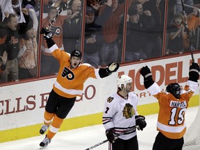 FILE - In this Jan. 5, 2012, file photo, Philadelphia Flyers' James van Riemsdyk (21), left, and Scott Hartnell (19) celebrate after van Riemsdyk's go-ahead goal as Chicago Blackhawks' Brent Seabrook (7) skates by in the third period of an NHL hockey game, in Philadelphia. Several players are returning to old teams and comfortable situations _ from James van Riemsdyk going back to Philadelphia on the second-richest July 1 deal to Matt Cullen taking a significant pay cut to rejoin the Pittsburgh Penguins he helped win the Stanley Cup twice.