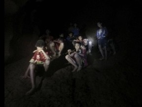 FILE - This Monday, July 2, 2018, file photo provided by Tham Luang Rescue Operation Center shows a group of Thai youth soccer players and their coach as they were found in a partially flooded cave in Mae Sai, Chiang Rai province, northern Thailand. For the boys and their coach, we have only a hint of what it might have been like. But for the rest of us, watching from afar as the world's journalists beamed us live shots and the unknowable became known drip by captivating drip, we knew only one thing: It was hard to look away. (Tham Luang Rescue Operation Center via AP, File)