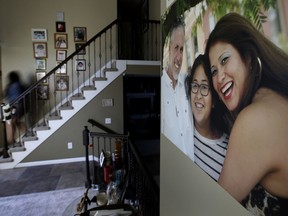 Jennifer Tadeo-Uscanga, 17, walks down a staircase lined with family photos at the Kansas City, Mo., home she once shared with her mother, Letty Stegall, on Thursday, May 24, 2018. Stegall, who lived in the United States for 20 years, was deported back to Mexico in March, leaving behind an American husband and daughter.