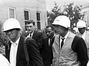 FILE - In this Oct. 1, 1962 file photo, James Meredith, center, is escorted by federal marshals as he appears for his first day of class at the previously all-white University of Mississippi, in Oxford, Miss. Meredith grew up in segregated Mississippi, served in the Air Force and sued to gain admission as the first black student at the state's flagship university. Facing resistance from the governor and riots that led to two deaths, Meredith enrolled at Ole Miss in 1962, under federal court order and protected by U.S. marshals. He graduated with a political science degree.