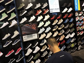 FILE - In this Aug. 22, 2017, file photo, a customer looks at shoes at a store in New York. Consumer spending rose by a solid 0.4 percent in June 2018, while a key gauge of inflation increased at an annual pace of 2.2 percent for a second straight month, the strongest back-to-back gains in six years.