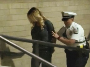 In this frame from video, porn actress Stormy Daniels is led into jail in Columbus, Ohio., after being taken into custody during a Wednesday evening, July 11, 2018, show. Daniels was arrested at a strip club and is accused of letting patrons touch her in violation of a state law, her attorney said early Thursday, July 12. (WBNS via AP)
