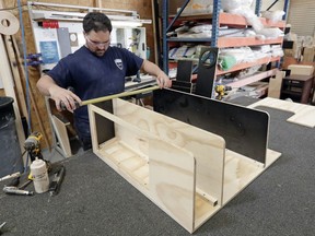 FILE- In this July 11, 2018, file photo a worker assembles interior cabinets for a boat at Regal Marine Industries in Orlando, Fla. On Tuesday, July 17, the Federal Reserve reports on U.S. industrial production for June.