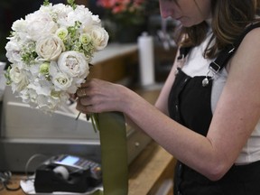 Sophia Gilberto wraps a bouquet in a flower shop, Thursday, June 7, 2018, in Chicago. The bouquet was made of peonies, roses and anemones. On Thursday, July 5, the Institute for Supply Management, a trade group of purchasing managers, issues its index of non-manufacturing activity for July.